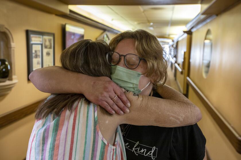 Salt Lake City, UT - September 08: Patti Larsen, 62, left, hugs Kellie Mieremet, right, the Community Engagement Manager at The INN Between on Thursday, Sept. 8, 2022, in Salt Lake City, UT. Patti was homeless for decades and had stage four lung cancer. She now lives at The Inn Between which is a care facility for end-of-life care and medical respite for people experiencing homelessness. Patti is receiving treatment for cancer and says her tumors are shrinking. She says The Inn Between is a place of hope for her and the other residents here. (Francine Orr / Los Angeles Times)