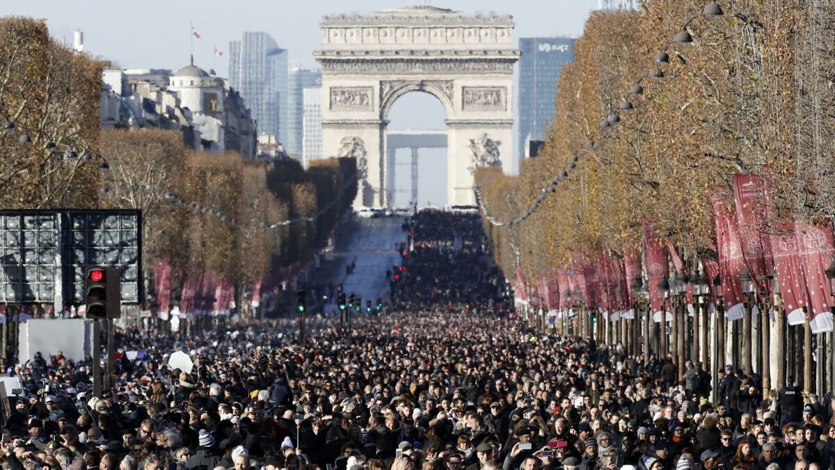 Vast crowds fill the streets of Paris on Dec. 9 to watch the funeral cortege of late French rock legend Johnny Hallyday.