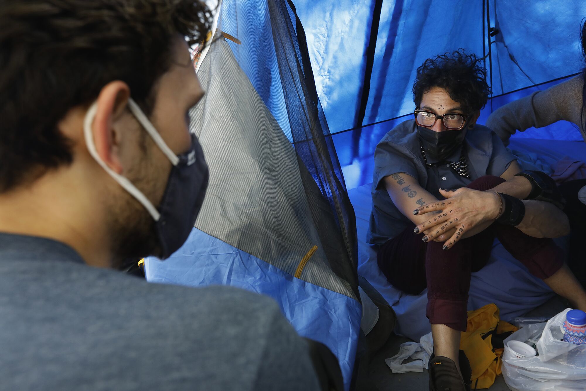 SELAH outreach worker Nick Marcone speaks to Bobby Rodriguez, who lives in a tent in Echo Park. 