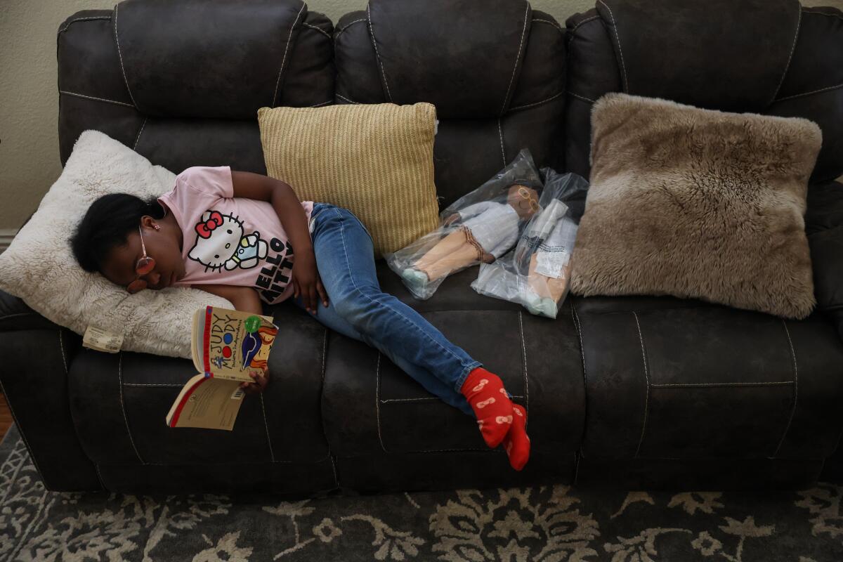 Honey Cooper catches up on reading at home in the afternoon between elementary school and her college nigh class.