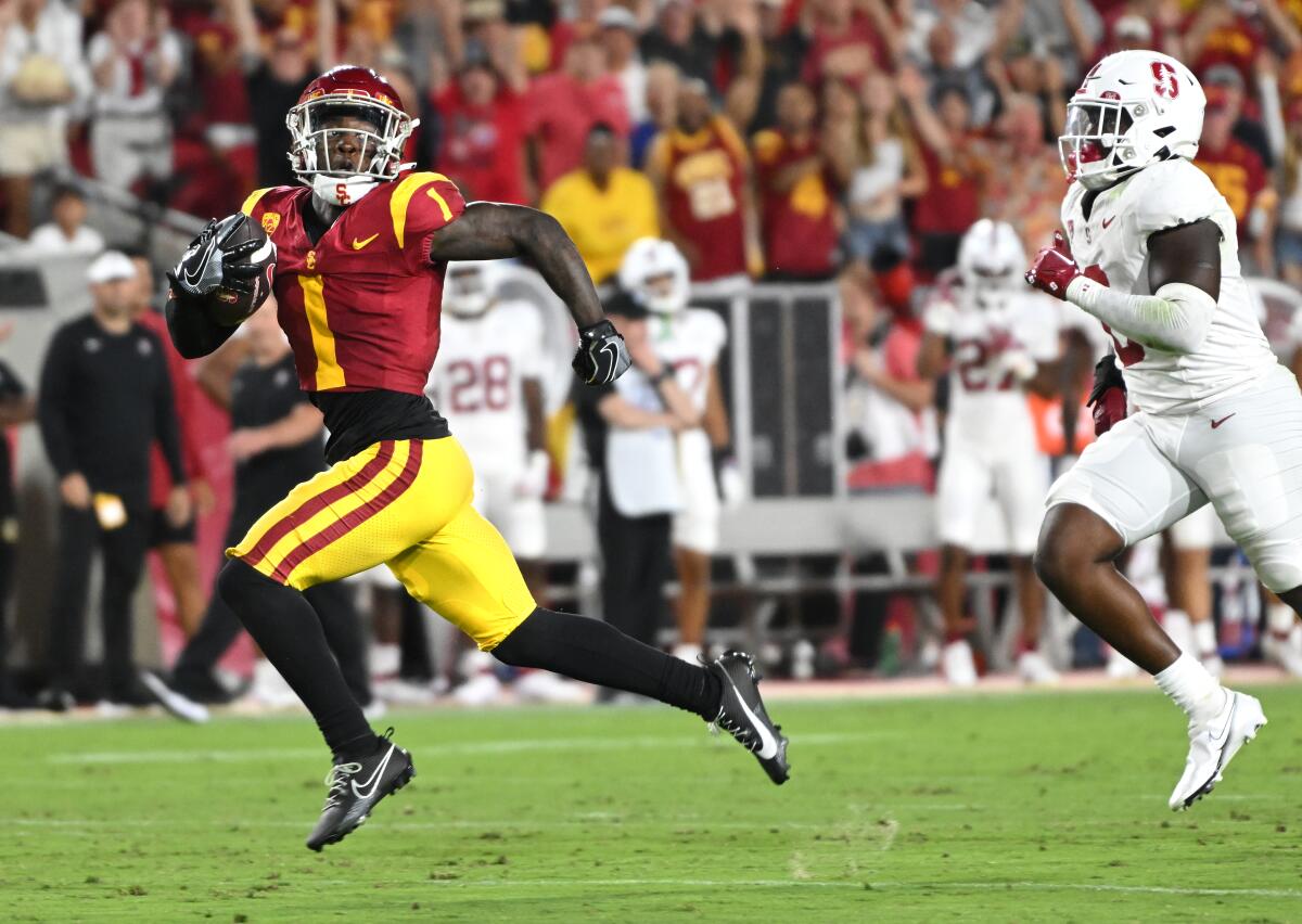 USC kick returner Zachariah Branch beats Stanford's Gaethan Bernadel for a touchdown.