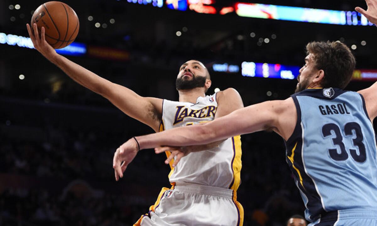 Lakers point guard Kendall Marshall, left, puts up a shot in front of Memphis Grizzlies center Marc Gasol during the first half of Sunday's game at Staples Center.
