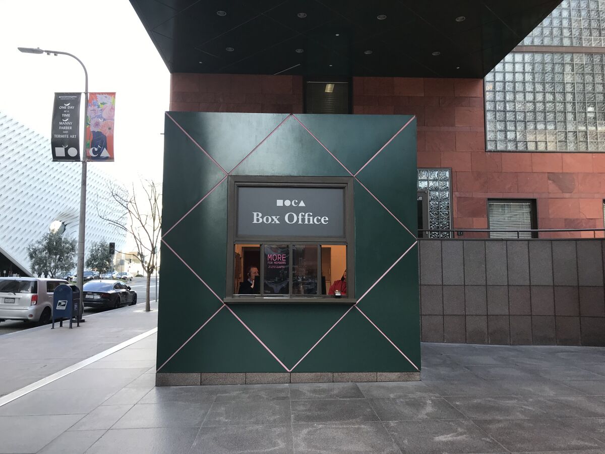 A small building next to a city sidewalk says "Box Office."