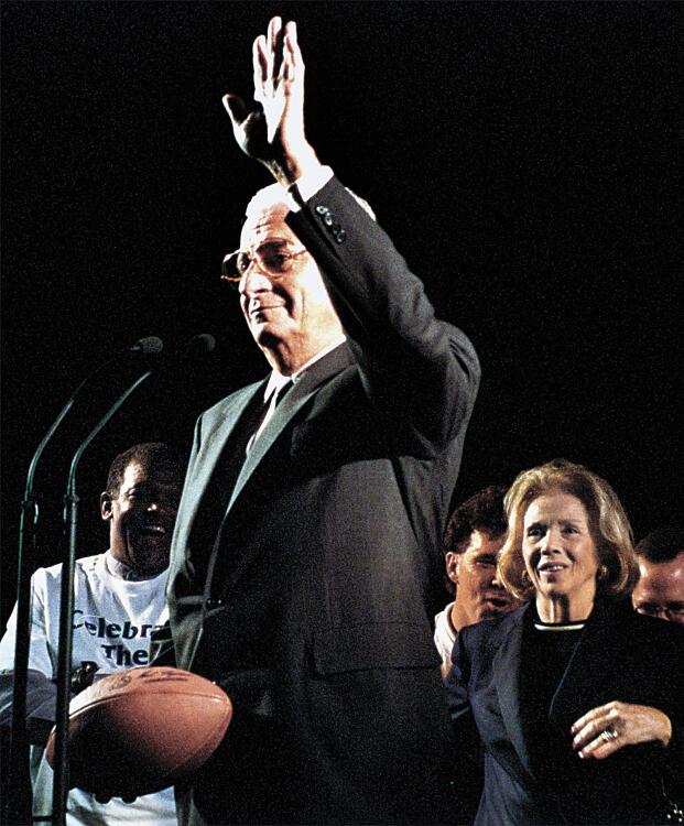 Baltimore Ravens owner Art Modell waves at the cheering crowd during a Ravens rally at the Inner Harbor. Modell spoke after 23 people handed off a football in a football relay that made its way down Charles Street from Mt. Vernon to the harbor. Behind Modell is his wife Pat, right.