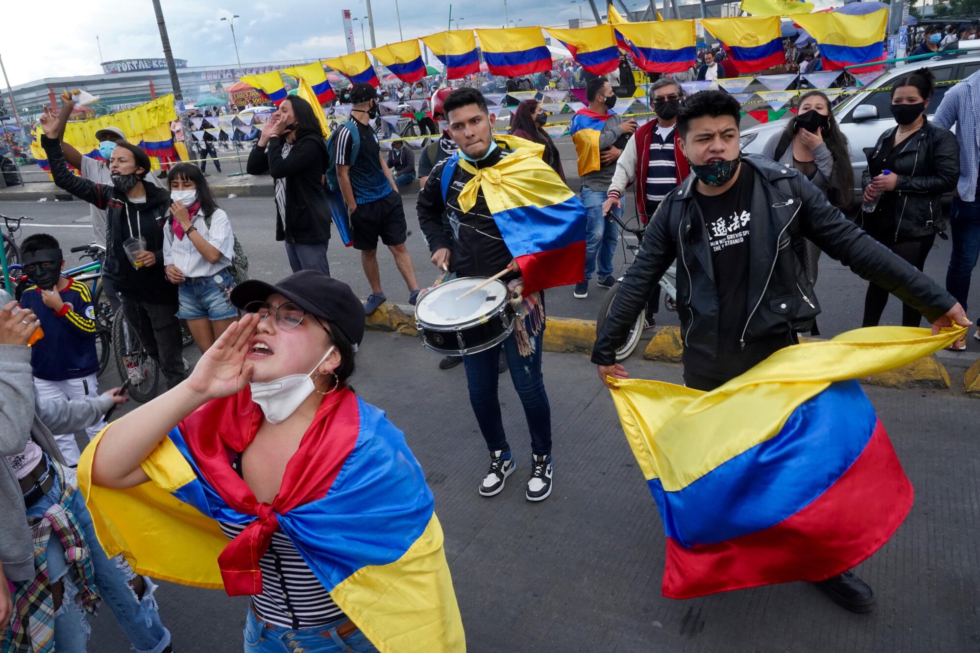 Young people wave flags, shout slogans and dance in the street during a protest in Bogota, Colombia.