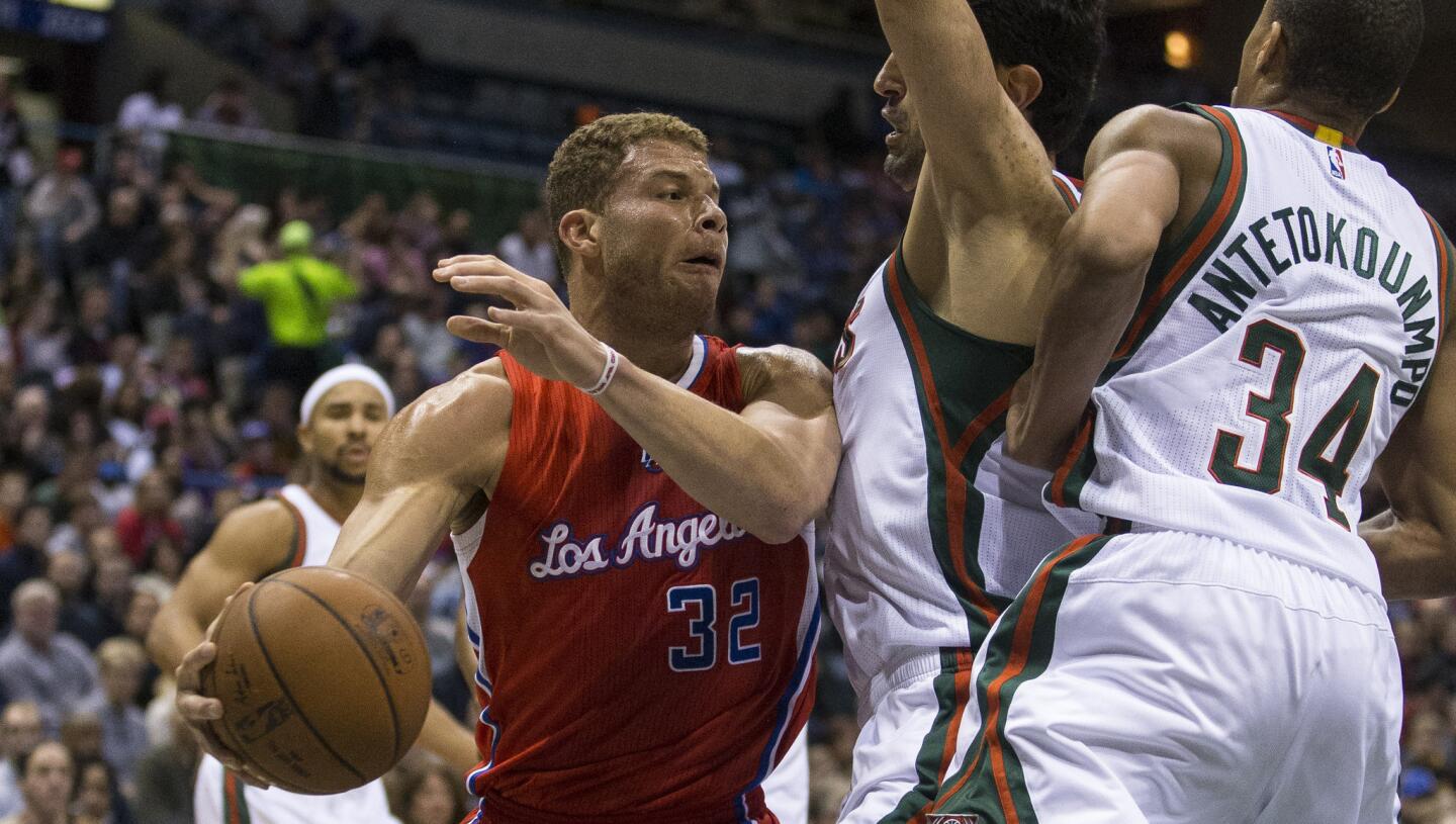Clippers forward Blake Griffin tries to pass the ball around Bucks forward Ersan Ilyasova and guard Giannis Antetokounmpo (34) in the first half.
