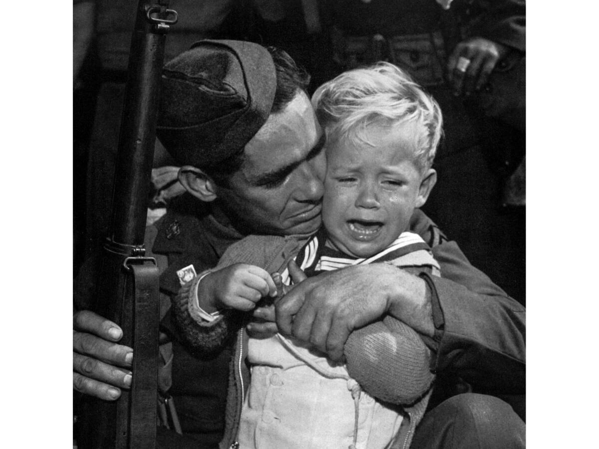 Oct. 31, 1940: Private John G. Winbury gives a hug to his son Robert Austin Winbury, 2, as he prepares to sail to Hawaii with the California 251st Coast Artillery, National Guard.