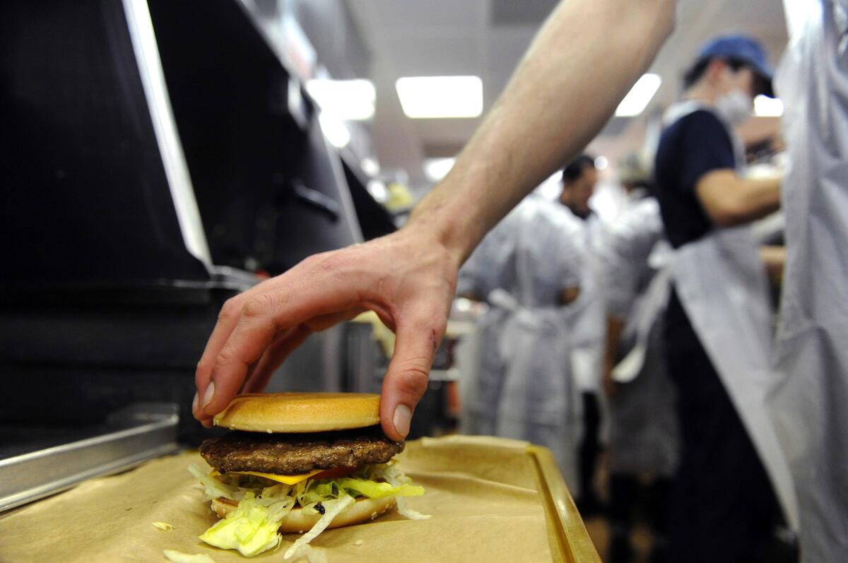 An employee prepares a hamburger.