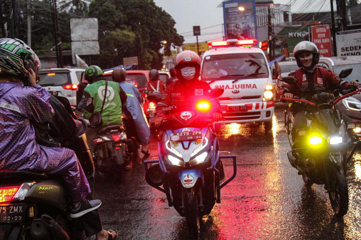 Motorcycles move along a street. 