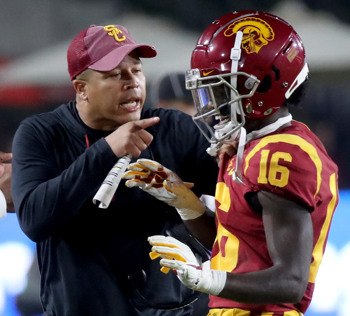 USC interim coach Donte Williams, left, speaks with receiver Tahj Washington during a win over Arizona on Oct. 30.
