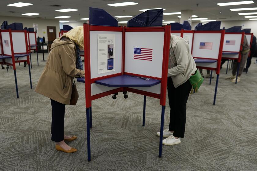 Voters stand in partitioned booths to fill out their ballots during early in-person voting at the Hamilton County Board of Elections in Cincinnati, Wednesday, Oct. 11, 2023. (AP Photo/Carolyn Kaster)