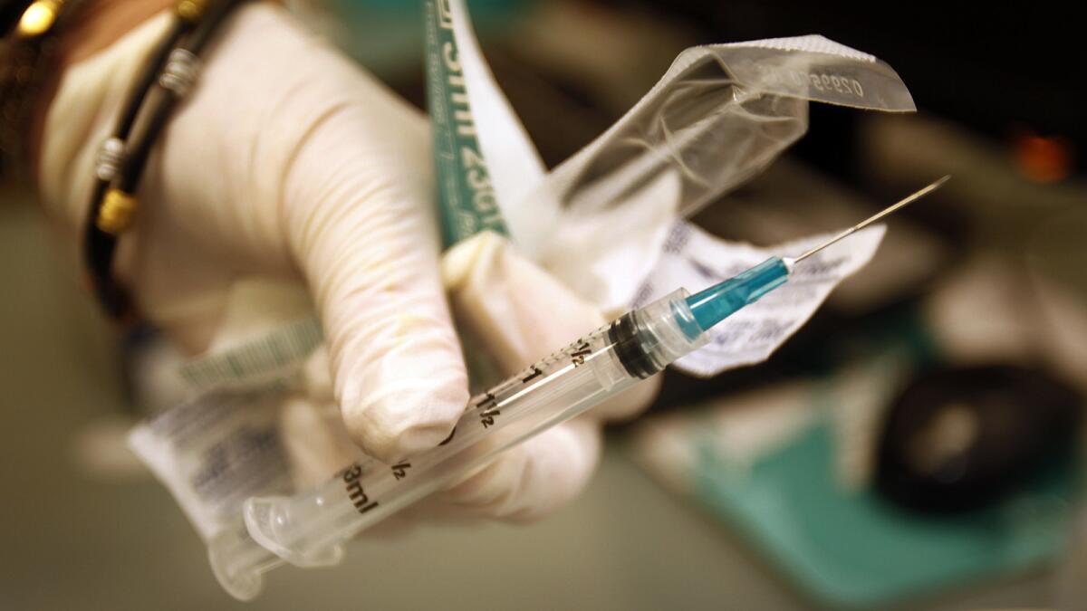 A clinical nurse holds a free meningitis vaccination at the AIDS Healthcare Foundation pharmacy in West Hollywood in 2013.