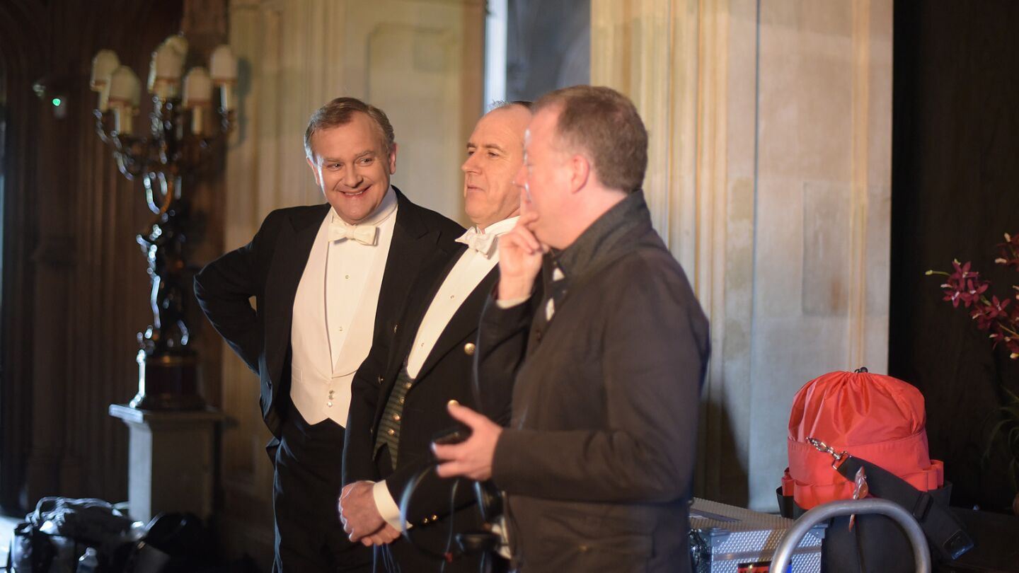 Hugh Bonneville and Kevin Doyle talk with crew members before filming a scene of "Downton Abbey" in the upstairs set at Highclere Castle.