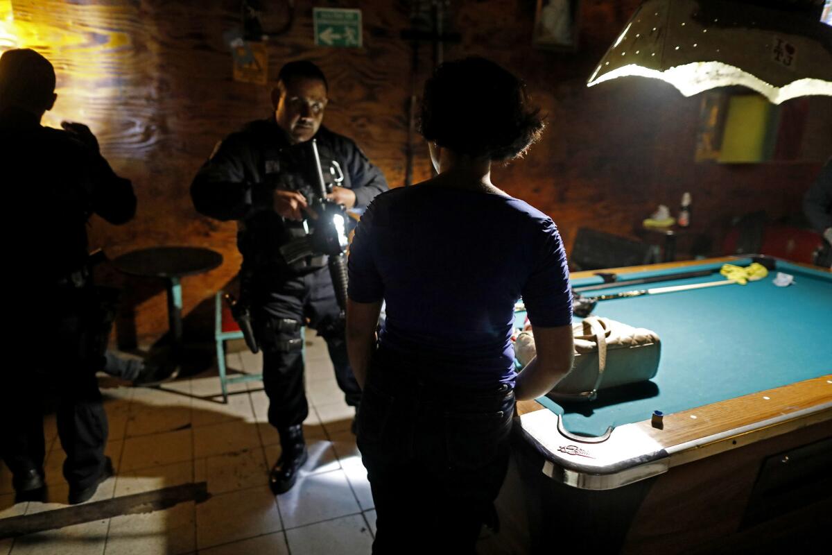 A specialized Tijuana City police unit checks people for drugs and guns at the Norteno Bar in the red-light district.