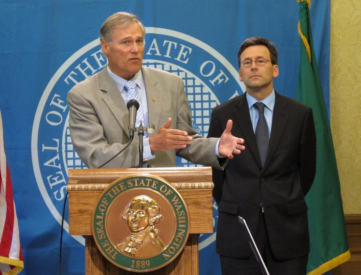 Washington Gov. Jay Inslee, left, is joined by state Atty. Gen. Bob Ferguson at a news conference to discuss the federal government's decision not to interfere with marijuana laws in Washington and Colorado.