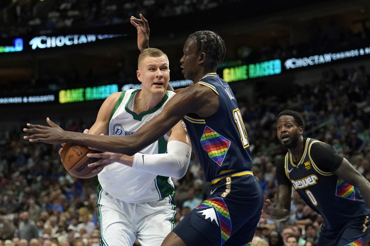 Dallas Mavericks center Kristaps Porzingis (6) works against Denver Nuggets center Bol Bol (10) for a shot attempt as forward JaMychal Green (0) looks on in the first half of an NBA basketball game in Dallas, Monday, Nov. 15, 2021. (AP Photo/Tony Gutierrez)