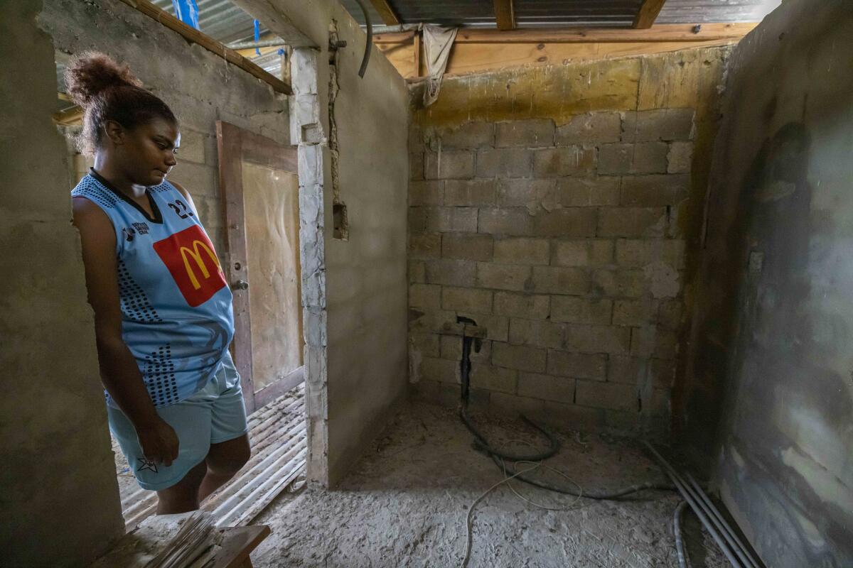 Jetsabel Osorio leans against a doorway in her hurricane-battered home.