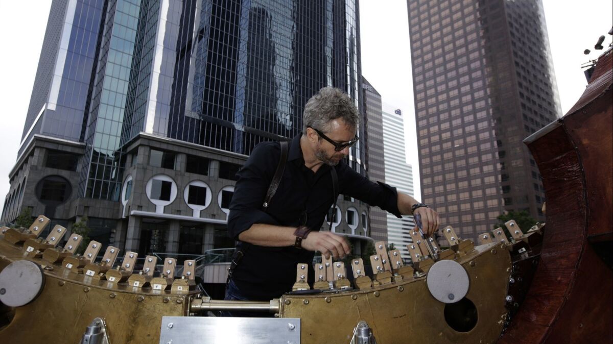 William Close prepares to string his Earth Harp, which is the largest playable stringed instrument in the world. This photo was taken before a performance in downtown Los Angeles in May 2017, when he connected the harp's strings to the skyscraper behind him.