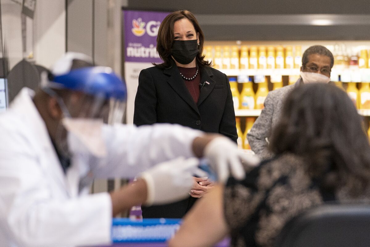 Vice President Kamala Harris watches a pharmacist administer a vaccine