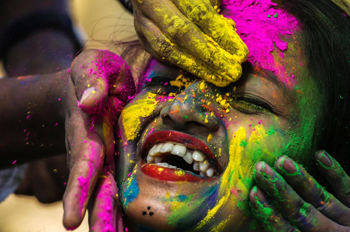 Revelers smear colored powder on a woman during celebrations marking Holi in Mumbai, India. (DIVYAKANT SOLANKI / EPA / REX / Shutterstock)