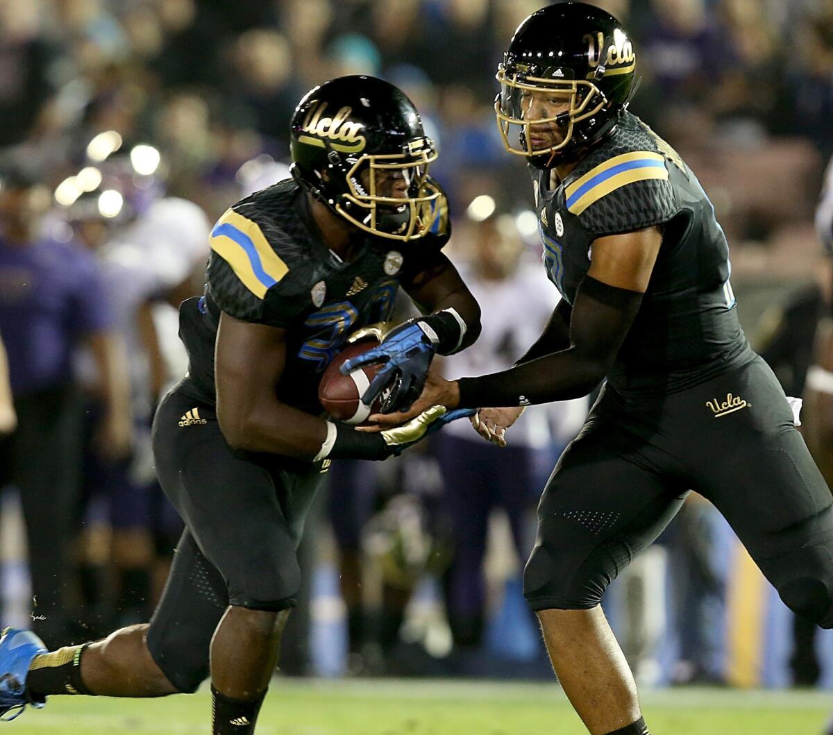 UCLA quarterback Brett Hundley hands off to Myles Jack during the Bruins' victory over Washington on Friday.