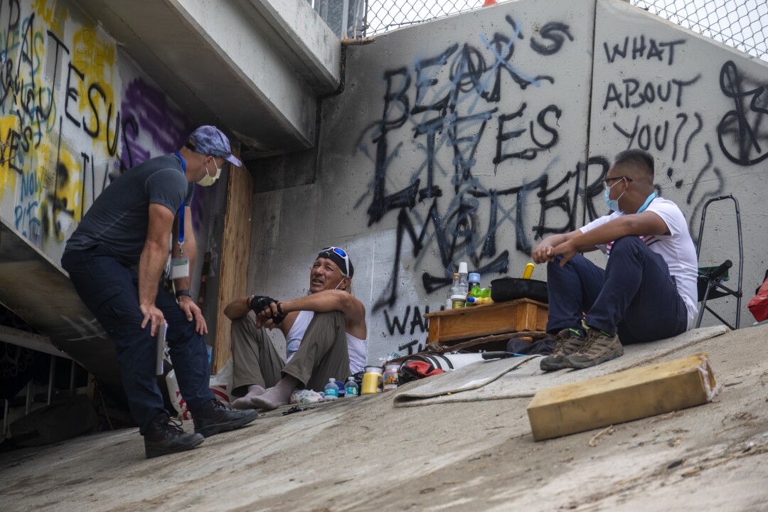 Daniel Newell, left, and Dr. Absalon Galat, right, listen to Barry Gadient, 60, middle