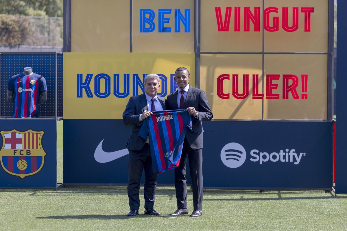 French defender Jules Kounde, right, poses with FC Barcelona president Joan Laporta during his official presentation after signing for FC Barcelona in Barcelona, Spain, Monday, Aug. 1, 2022. (AP Photo/Joan Monfort)