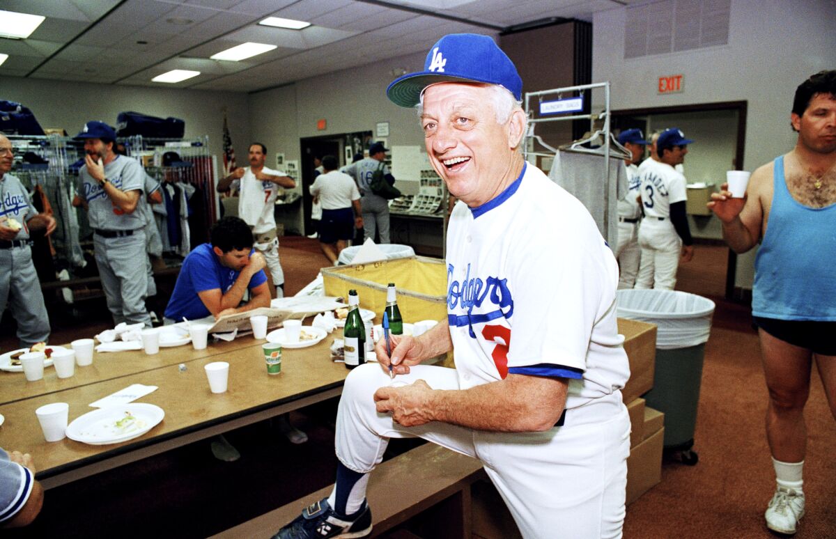 Dodgers manager Tommy Lasorda autographs a baseball inside the Dodgertown locker room on Feb. 15, 1990.