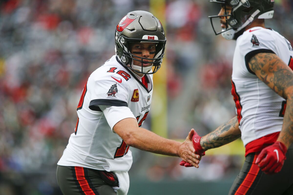 Tampa Bay Buccaneers quarterback Tom Brady, left, celebrates with Mike Evans after Evans scored a touchdown during the first half of an NFL football game against the New York Jets, Sunday, Jan. 2, 2022, in East Rutherford, N.J. (AP Photo/John Munson)
