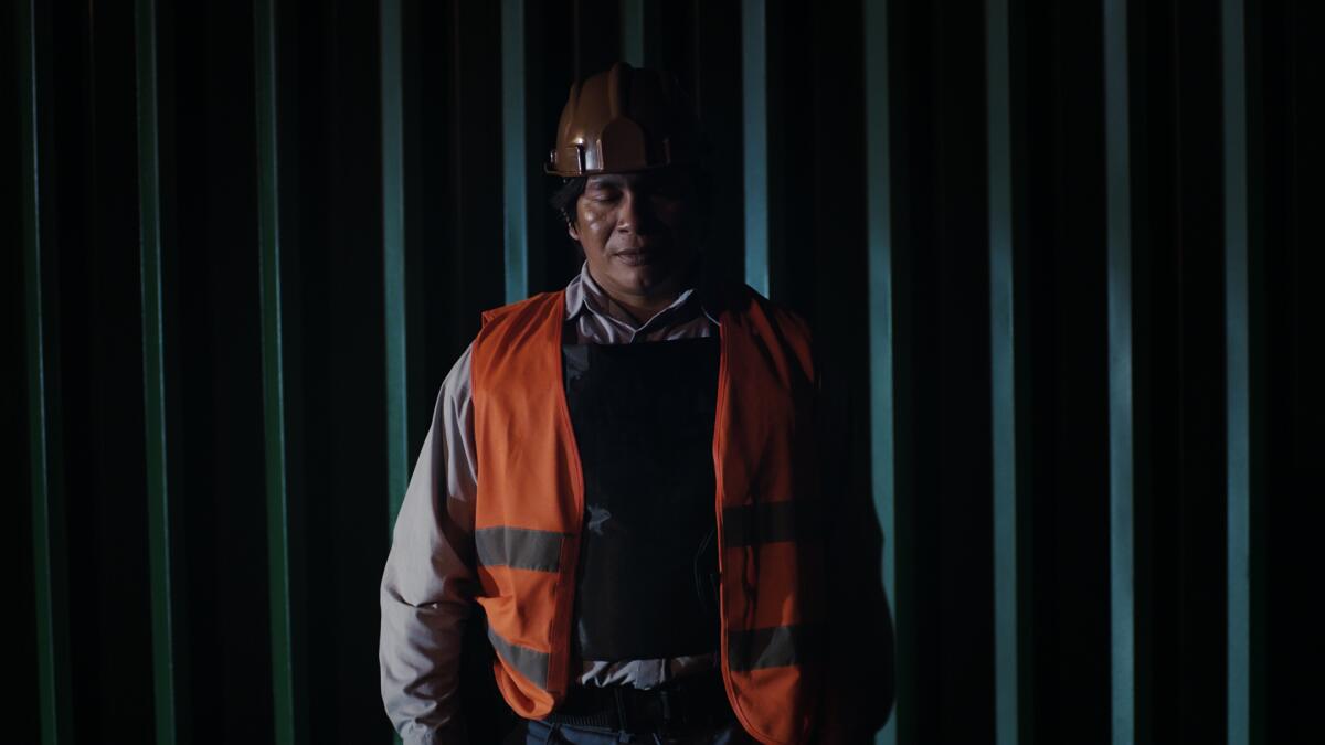 A man in an orange safety vest in the movie "The Fever," directed by Maya Da-Rin.