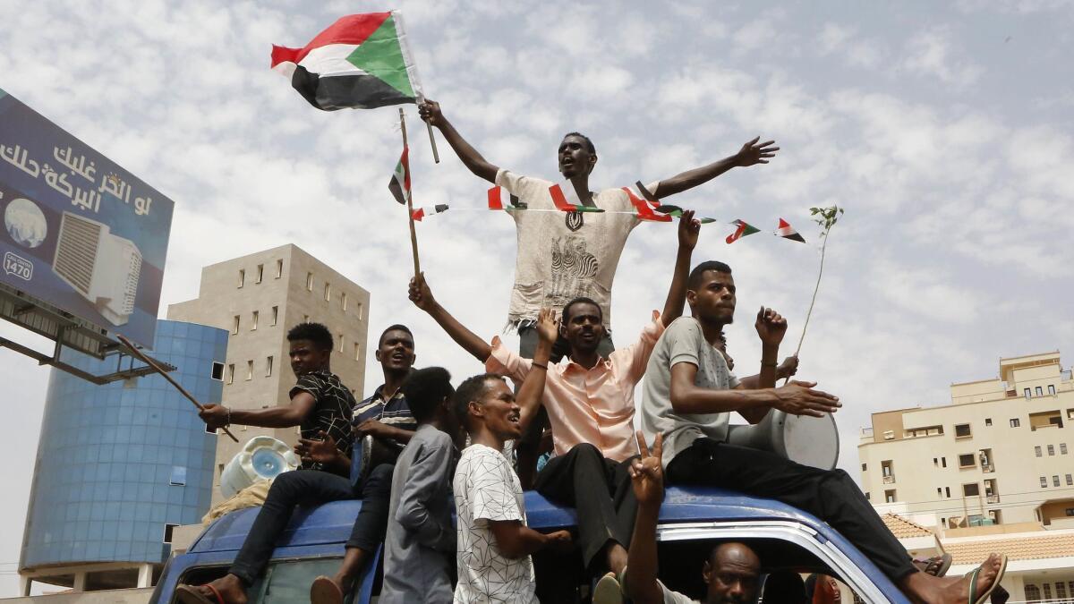 Sudanese protesters celebrate in the streets of Khartoum after ruling generals and protest leaders announced they have reached a new power-sharing agreement.