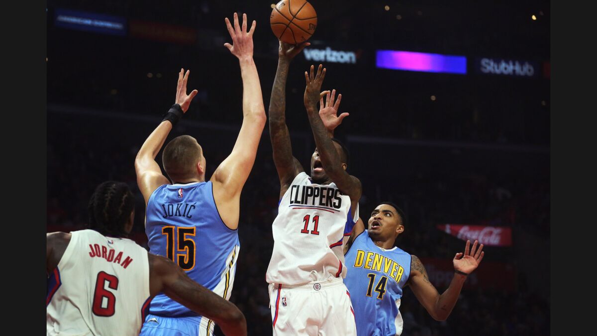 Clippers guard Jamal Crawford goes up for a shot as Denver Nuggets forward Nikola Jokic and guard Gary Harris converge on Dec. 26.