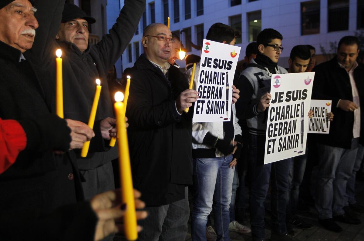 Lebanese protesters hold candles and placards reading in French "I am Charlie, Gebran and Samir' during a gathering in solidarity with victims of the Charlie Hebdo attack.