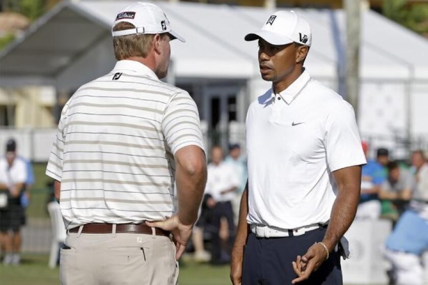 Steve Stricker, left, gives some advice to Tiger Woods on the practice putting green.