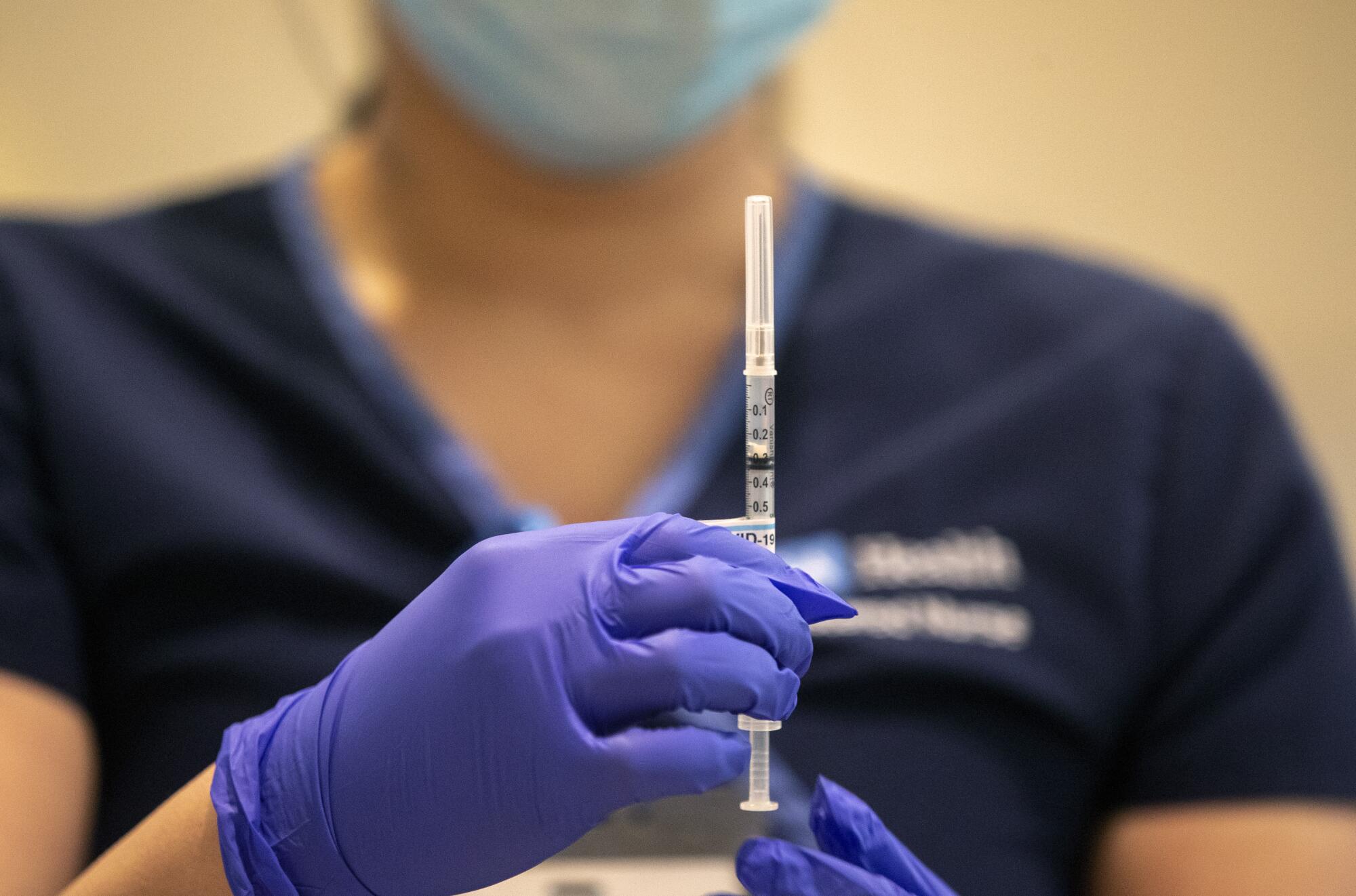 Nurse Eunice Lee prepares administer an injection of the vaccine.