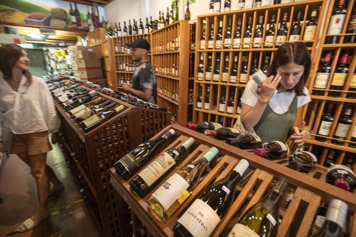 A woman looks at bottles of wine inside Larchmont Village Wine, Spirits & Cheese.