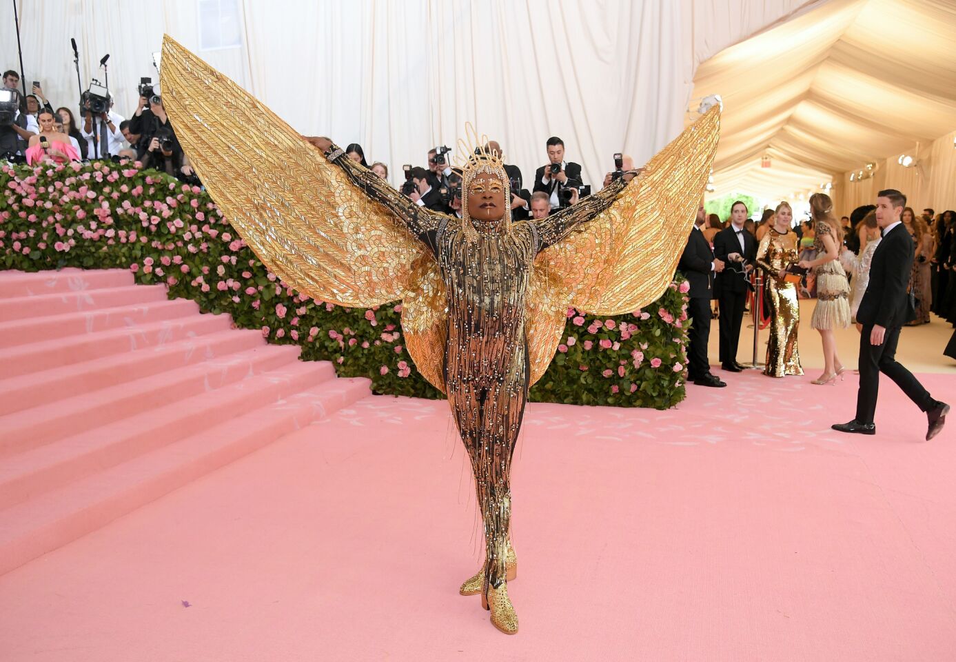 Billy Porter reveals his outfit's wings on the Met Gala red carpet.