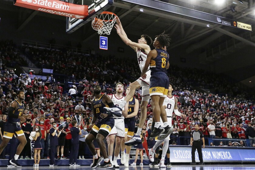 Gonzaga center Chet Holmgren, center left, dunks next to Merrimack guard Malik Edmead during the first half of an NCAA college basketball game, Thursday, Dec. 9, 2021, in Spokane, Wash. (AP Photo/Young Kwak)