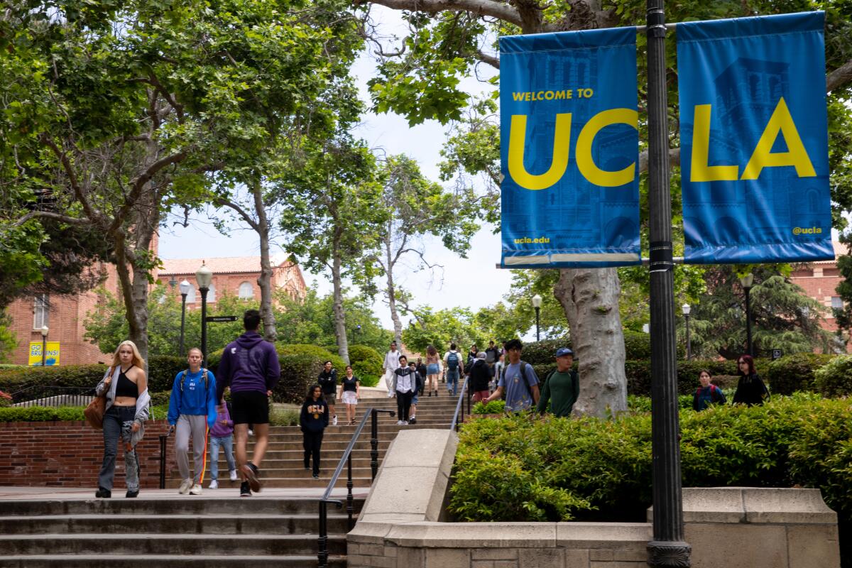 Students walk on campus near a "Welcome to UCLA" banner
