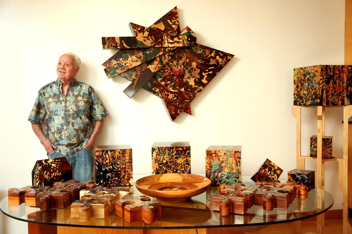 An artist poses next to his work.