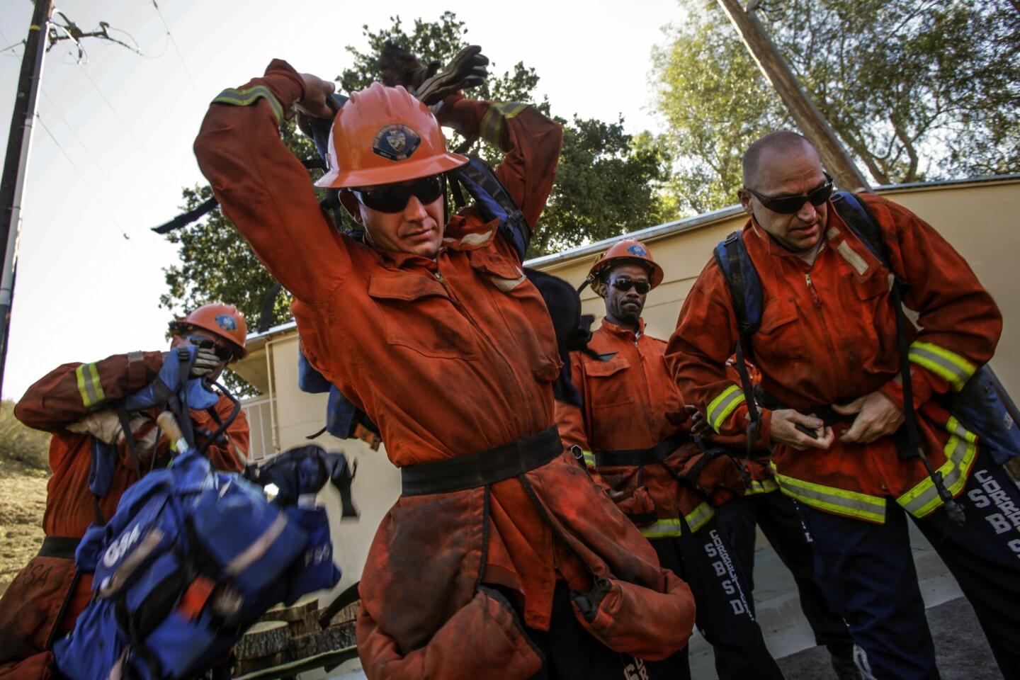 James Jones, 26, of Barstow, center, Tim Johnson, 49, far right, and other members of the Glen Helen 1 fire crew get ready for a hike near their fire camp at Glen Helen Rehabilitation Center in September. Johnson has since been released.