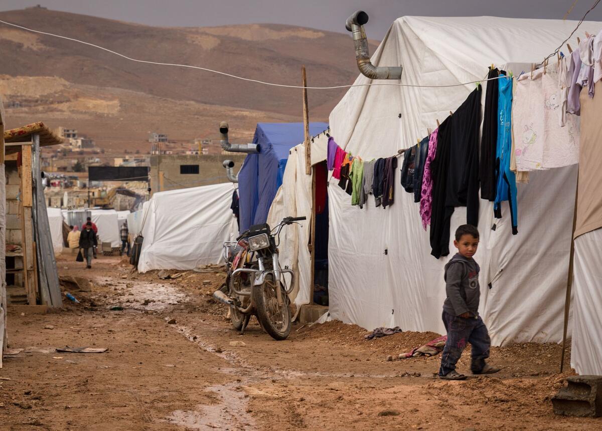 A young Syrian refugee walks past tents at the Al-Nihaya camp in the eastern Lebanese town of Arsal on Oct. 23.