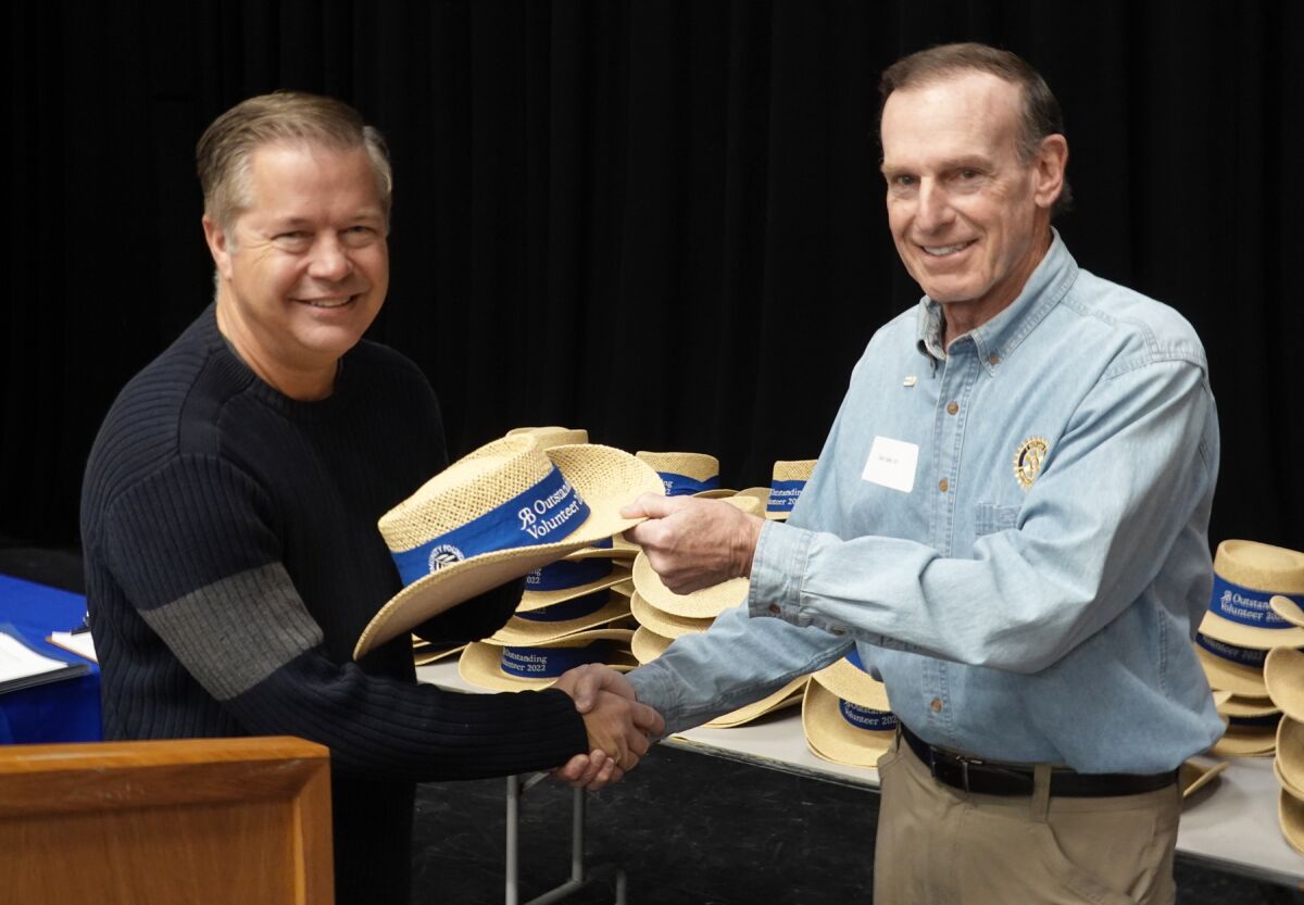 RB High School Principal Hans Becker presenting a hat to honoree Gary Saks of the RB Rotary Club.