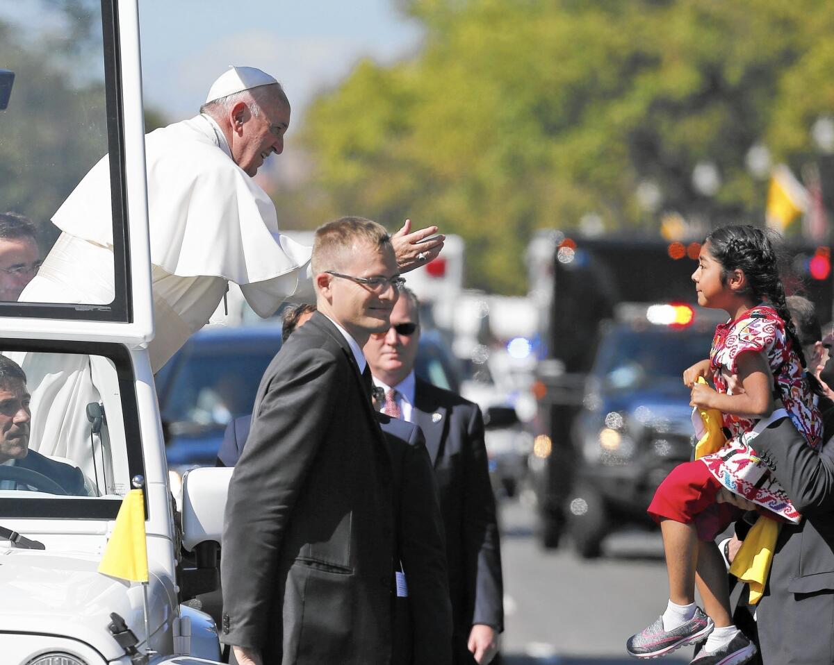 Pope Francis reaches for a letter and a gift from Sophie Cruz, 5, of suburban Los Angeles, as he makes his way through Washington.
