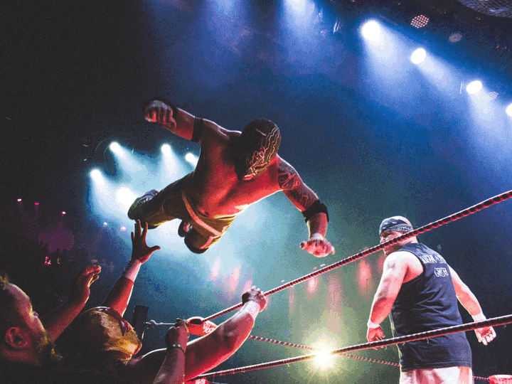 A slideshow features an airborne masked wrestler, two actors in a fantastical milieu and a vocal ensemble in an ornate church