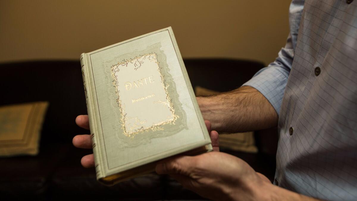 Dan Whitmore holds up "The Vision; or Hell, Purgatory, and Paradise of Dante Alighieri" illustrated by Gustave Dore.