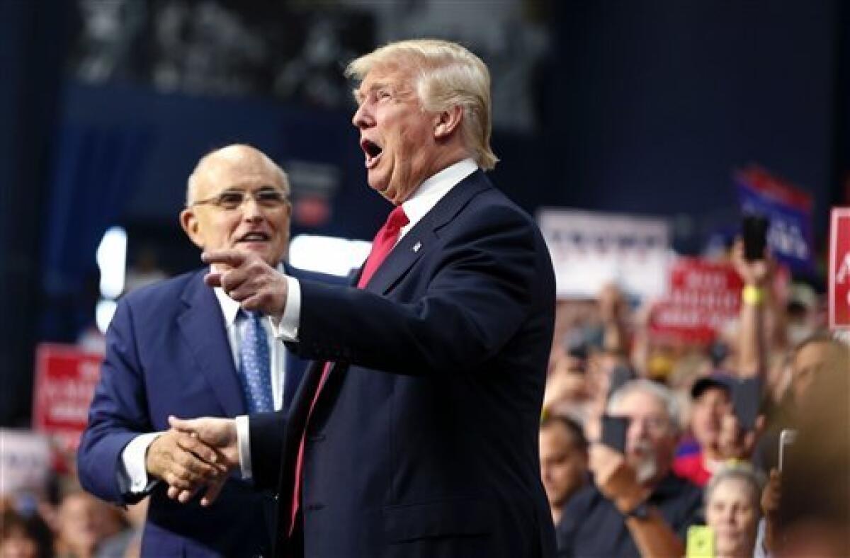 El candidato republicano a la presidencia de EEUU, Donald Trump, llega a un acto de campaña en Akron, Ohio, el lunes 22 de agosto de 2016. Detrás se ve al exalcalde de Nueva York Rudy Giuliani.