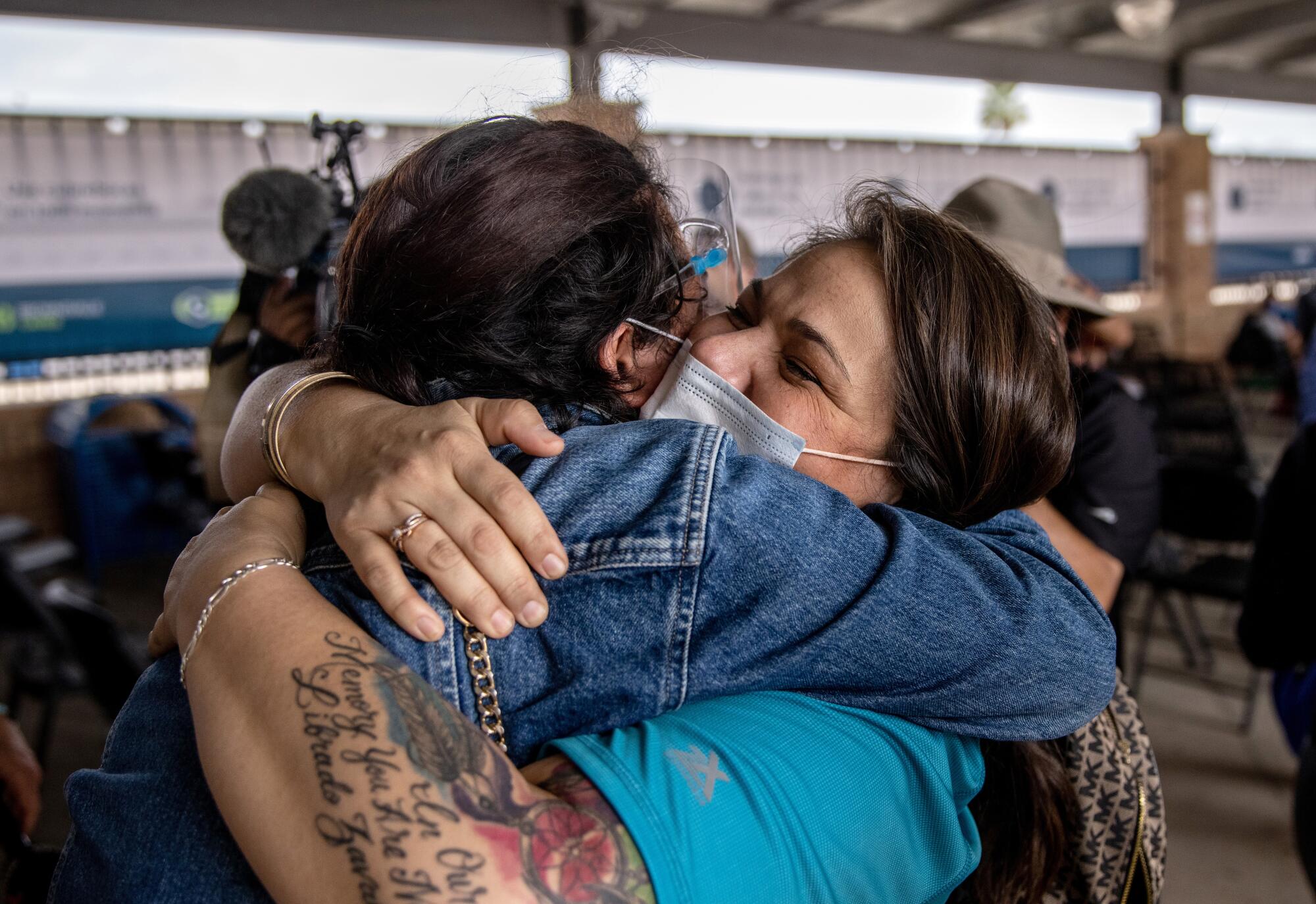 Two people hug.