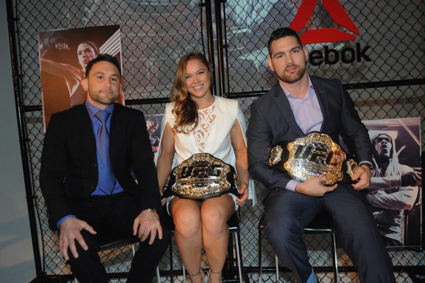 Ronda Rousey, center, and Chris Weidman, right, with Frankie Edgar in New York on Dec. 2.