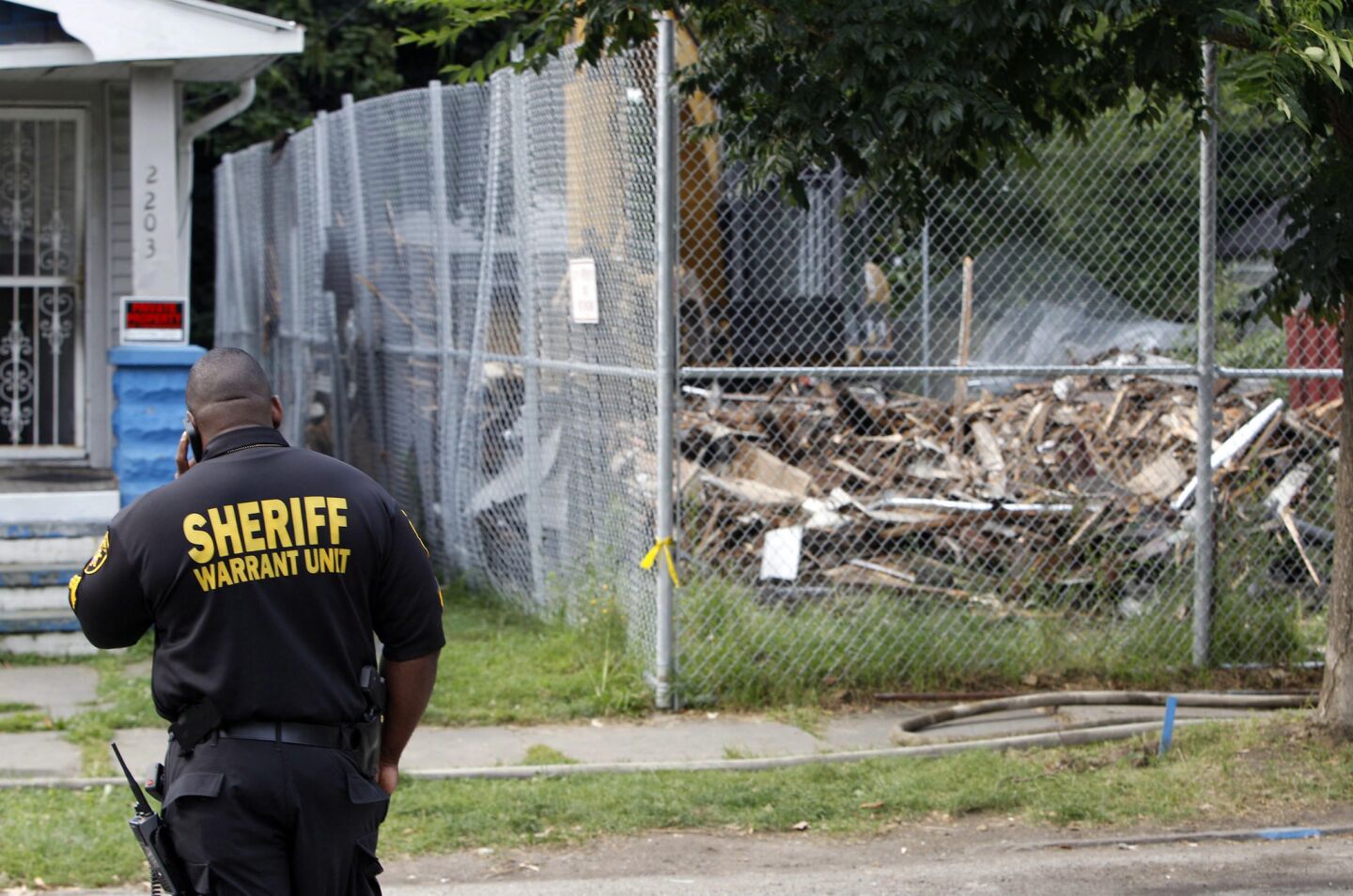 A sheriff's deputy stands guard as the house of convicted kidnapper and rapist Ariel Castro is torn down in Cleveland.
